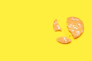 Tasty broken cookie with chocolate chips on color background