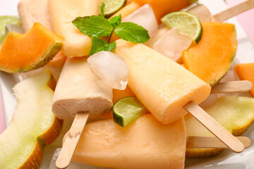 Plate with tasty melon popsicles on color background