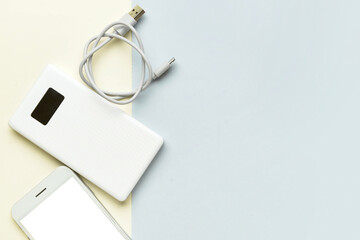 Modern power bank and mobile phone on color background