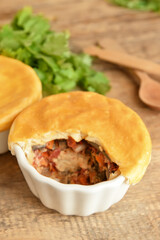 Tasty vegetable pot pies on wooden background