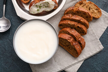 Bowl of lard spread and bread pieces on black background