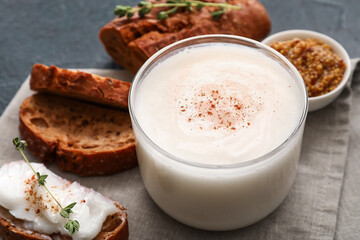 Jar of lard spread and bread pieces on black background