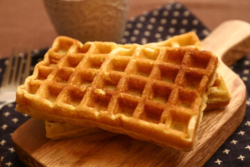Wooden board of tasty Belgian Waffles on table in cafe