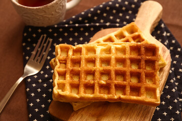 Wooden board of tasty Belgian Waffles on table in cafe