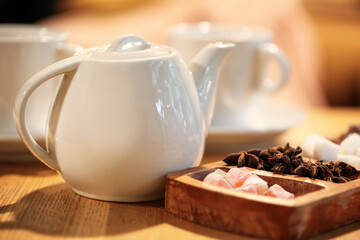 Tea pot, Turkish delight and star anise on table in cafe