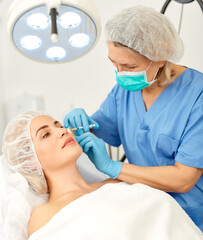 Portrait of woman during beauty facial injections in medical esthetic office. High quality photo