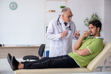 Obraz premium Young male patient visiting old male doctor