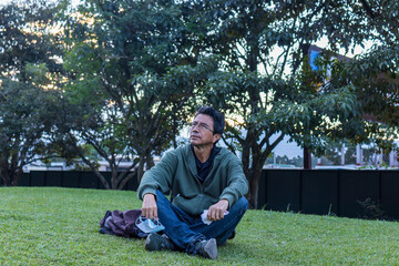 Hispanic man in a  park breathing fresh air, the pandemic is over concept