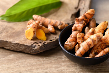 Fresh turmeric in a bowl on wooden background, Food ingredients in Asian food and used in beauty spa and herbal medicine