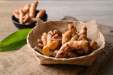 Fresh turmeric in a basket on wooden background, Food ingredients in Asian food and used in beauty spa and herbal medicine