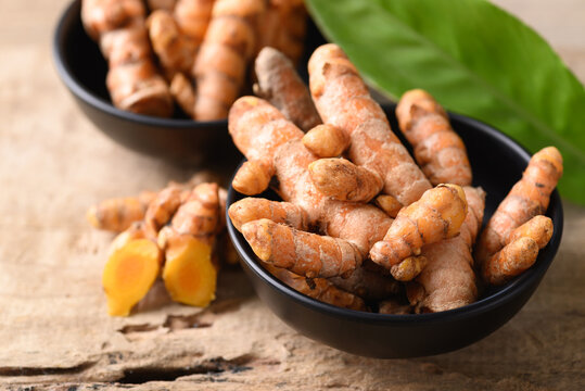 Fresh turmeric in a bowl on wooden background, Food ingredients in Asian food and used in beauty spa and herbal medicine