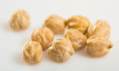 Dried chickpea groats scattered on white surface