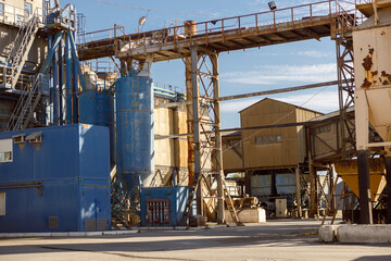 Territory of manufacturing plant with buildings, industrial equipment, warehouses and ladders