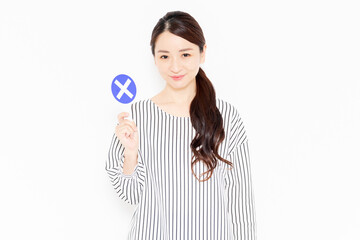 NGのポーズをするカジュアルな服装の女性