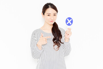 NGのポーズをするカジュアルな服装の女性