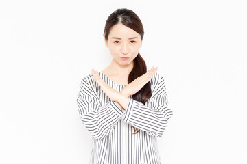 NGのポーズをするカジュアルな服装の女性