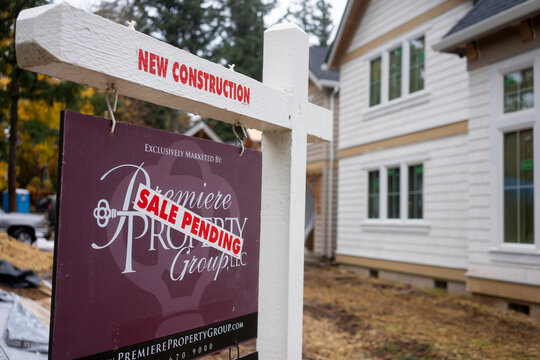 Lake Oswego, OR, USA - Nov 2, 2021: A Sale Pending sticker is seen on a real estate yard sign made by the Premiere Property Group outside a newly-constructed single family home in Lake Oswego, Oregon.