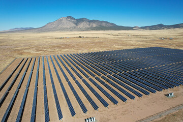 Aerial drone shot of a large solar array power plant in the desert generating clean electricity from the sun.