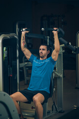 young man exercising lats on machine