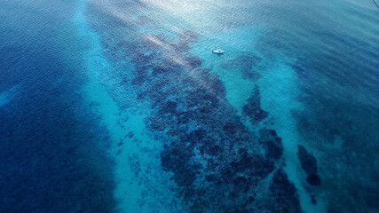 Aerial view of yacht on the water surface from top view. Turquoise water background from top view....