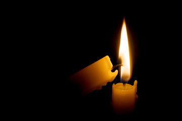 Burning candle in the darkness. Lighting candle with another one.