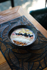 smoothie bowl with mix of almonds, coconut, blueberries, strawberries, and bananas