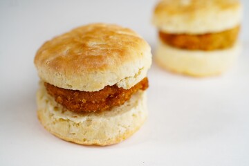 Chicken biscuit sandwich or sliders on white background, selective focus
