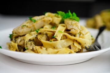 Homemade fettuccine chicken Alfredo pasta on white background
