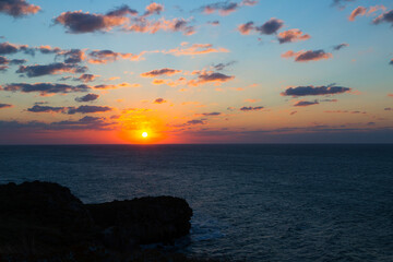Beautiful sunset over sea with reflection in water, majestic clouds in the sky