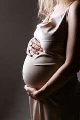 caucasian pregnant woman stroking her belly on white background. Copy space. The concept of healthy digestion, lifestyle, IVF