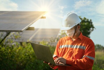 Engineering industry uniform working test and checking for maintenance in solar power plant by Notebook computer.operation and maintenance in solar power plant to innovation of green energy for life