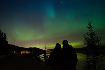 Couple enjoying the northern lights in Whitehorse, Yukon(Canada).