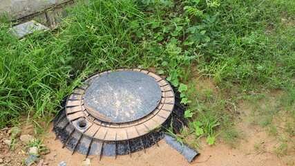 Black PE septic tank. Plastic septic tank is buried in the ground with green grass for treating...