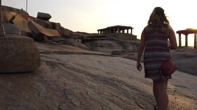 Tourist Climbing Rock to Watch Sunset at Hampi Archaeological Site, Karnataka, India