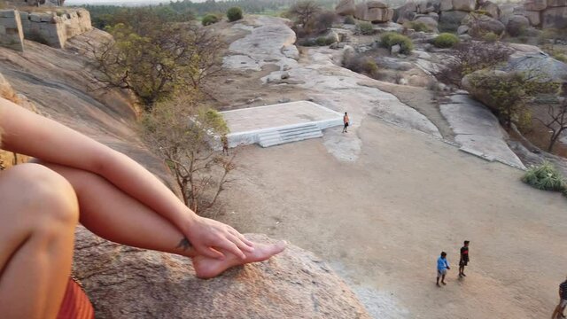 Beautiful Tourist Looking at Local Boys Playing Cricket Among the Temples of Hampi at Sunset at Karnataka, India.