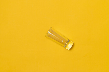 top view of shot glass for tequila, on yellow background