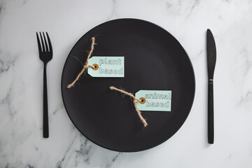 plant-based and animal-based product tags on top of black dining plate on marble table, healthy...