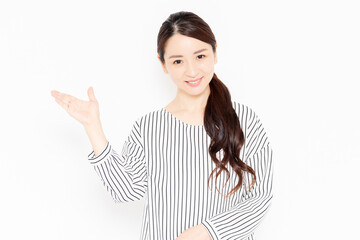 案内のポーズをするカジュアルな服装の女性
