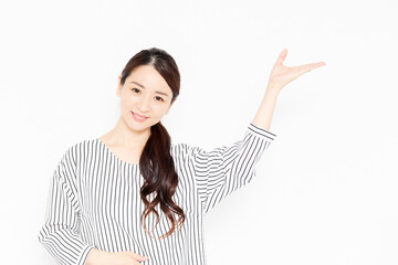 案内のポーズをするカジュアルな服装の女性