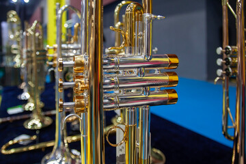 Shiny metal musical trumpet close up, piston valves, pipes, music shop