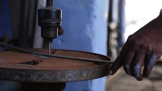 Hand of man at work with old rusty electric drill in laboratory of Sakhi Saheli village, Rajasthan