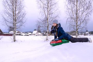 Fototapeta na wymiar Beautiful girl rides downhill in winter
