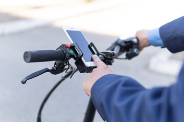 Close up of man using smartphone to rent an e-kick vehicle. Millennial guy with mobile phone using...