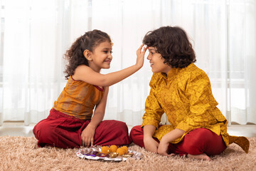 Little Girl applying tika on forehead of her brother on the occasion of Bhai Dooj