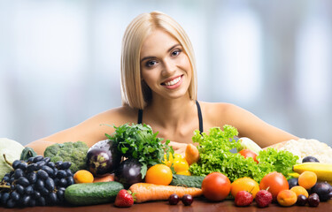 Healthy eating and vegan diet studio concept image - portrait of happy smiling beautiful blond woman with vegetarian food, fruits and vegetables, indoors.
