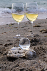 Romantic glass of white wine, on the sea beach. Wine tasting and relaxation at the resort