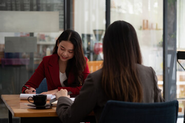 Fototapeta premium Young Asian businesswoman work together to analysis from work at the office