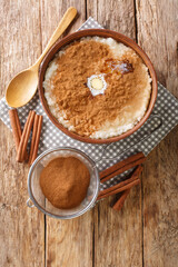Risengrod which is rice pudding or porridge Danish Christmas food close up in the bowl on the table. Vertical top view from above