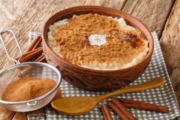 Cinnamon rice pudding risengrod close up in the bowl on the table. Horizontal