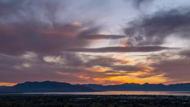 Timelapse during sunset looking over Provo as clouds change colors looking towards West Mountain over Utah Lake.